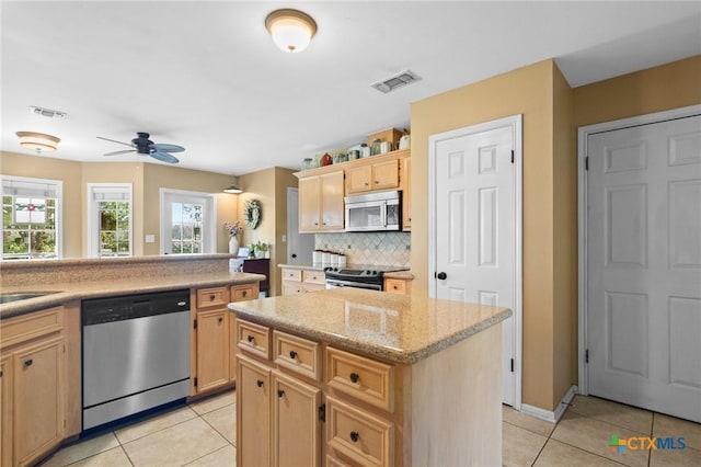 4 Longview Dr, Victoria, TX 77904 - kitchen featuring stainless steel appliances, light tile patterned floors, light brown cabinets, and backsplash
