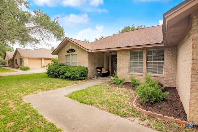 4 Longview Dr, Victoria, TX 77904 - view of front of home with brick siding, a front lawn, a garage, and roof with shingles