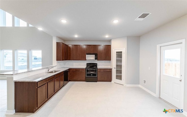 308 Angus Dr, Seguin, TX 78155 - kitchen with a sink, visible vents, recessed lighting, light stone counters, and black appliances