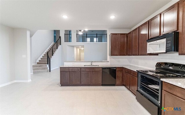 308 Angus Dr, Seguin, TX 78155 - kitchen featuring a peninsula, a sink, baseboards, dark brown cabinetry, and black appliances
