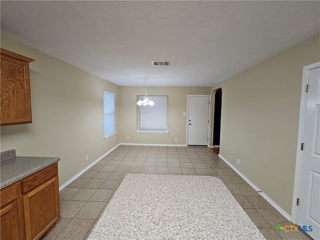 dining space with a notable chandelier and light tile patterned flooring