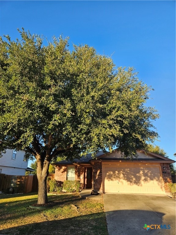 obstructed view of property featuring a garage and a front yard