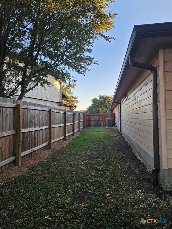 yard at dusk featuring cooling unit