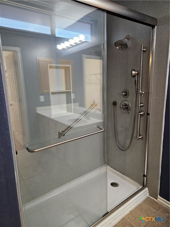 bathroom featuring tile patterned floors and a shower with shower door