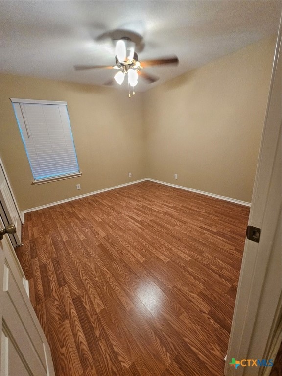 unfurnished room with ceiling fan and wood-type flooring