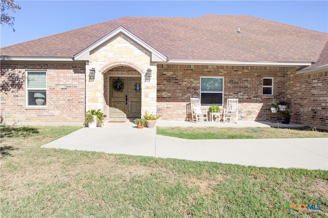 single story home with a patio area and a front lawn