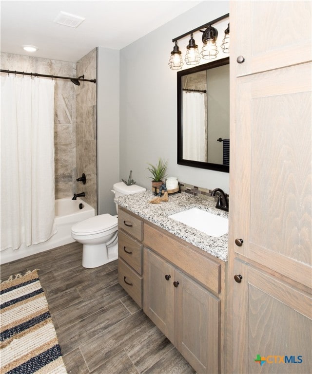 full bathroom featuring shower / bath combination with curtain, toilet, wood-type flooring, and vanity