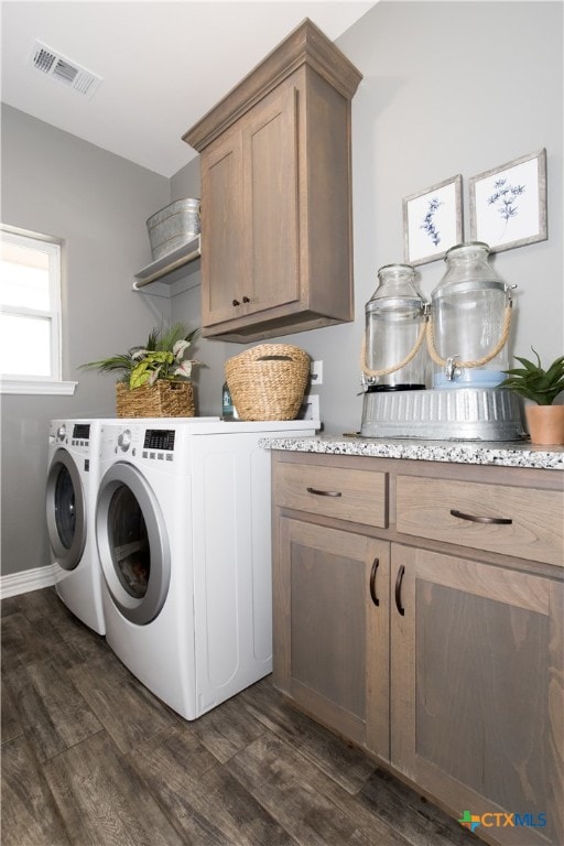 laundry area with cabinets, dark hardwood / wood-style floors, and washer and dryer