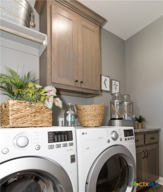 clothes washing area with cabinets and independent washer and dryer