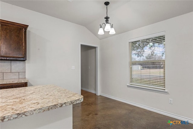 unfurnished dining area with vaulted ceiling and a chandelier