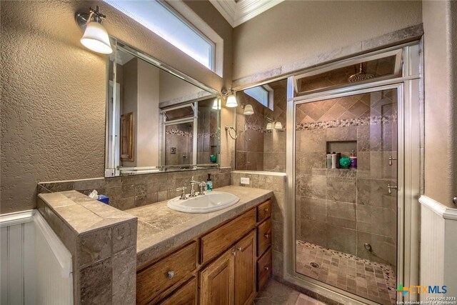 547 Powder Rdg, Luling, TX 78648 - full bathroom with a shower stall, vanity, crown molding, a textured wall, and a wainscoted wall