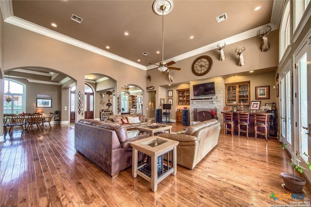 547 Powder Rdg, Luling, TX 78648 - living room with arched walkways, ornamental molding, a ceiling fan, wood-type flooring, and a large fireplace