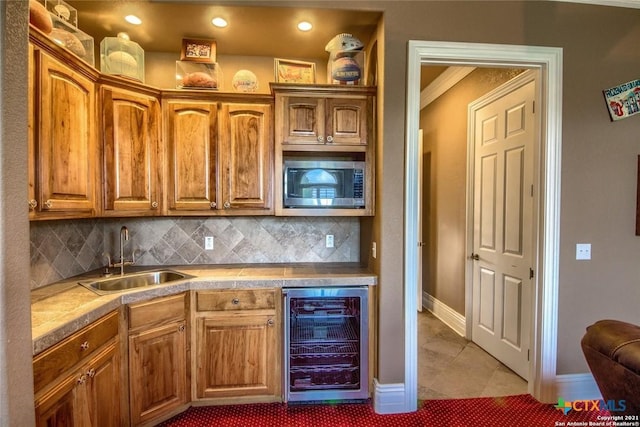 547 Powder Rdg, Luling, TX 78648 - kitchen featuring wine cooler, stainless steel microwave, backsplash, brown cabinets, and recessed lighting
