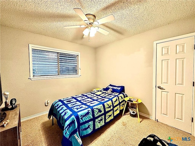 carpeted bedroom featuring ceiling fan and a textured ceiling