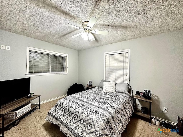 carpeted bedroom with ceiling fan and a textured ceiling