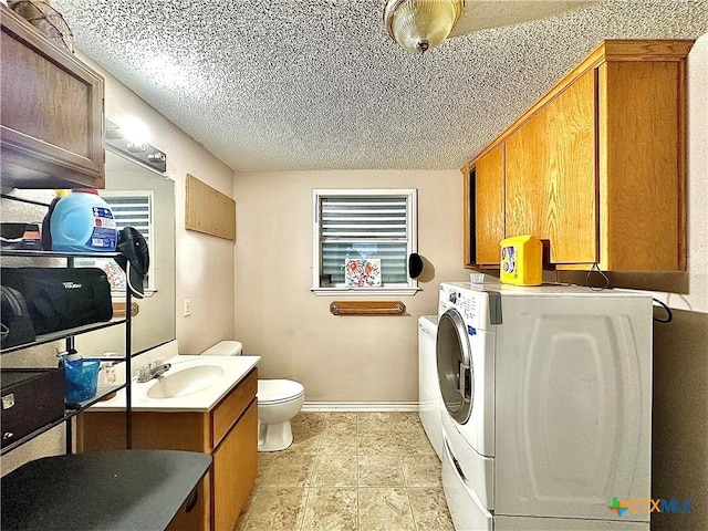 laundry area featuring washing machine and clothes dryer, sink, and a textured ceiling