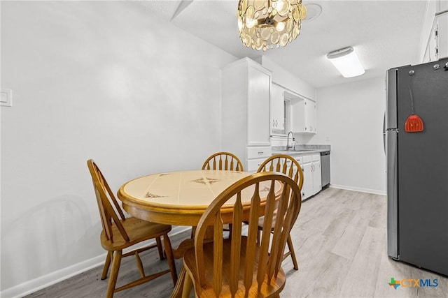1206 Amthor Ave, Copperas Cove, TX 76522 - dining area with light wood finished floors, a chandelier, and baseboards