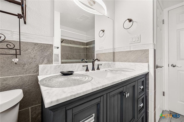 1206 Amthor Ave, Copperas Cove, TX 76522 - bathroom featuring tile walls, vanity, toilet, and tiled shower