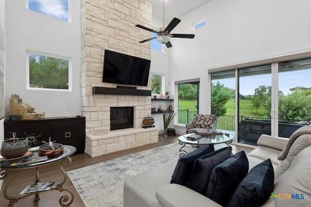 119 Rivalto Dr, Horseshoe Bay, TX 78657 - living area featuring a high ceiling, a ceiling fan, a fireplace, and wood finished floors