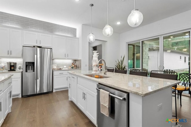 119 Rivalto Dr, Horseshoe Bay, TX 78657 - kitchen featuring appliances with stainless steel finishes, a sink, dark wood-style flooring, tasteful backsplash, and a kitchen island with sink