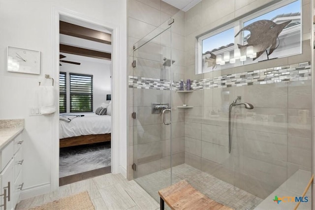 119 Rivalto Dr, Horseshoe Bay, TX 78657 - ensuite bathroom featuring vanity, a shower stall, baseboards, ceiling fan, and beam ceiling