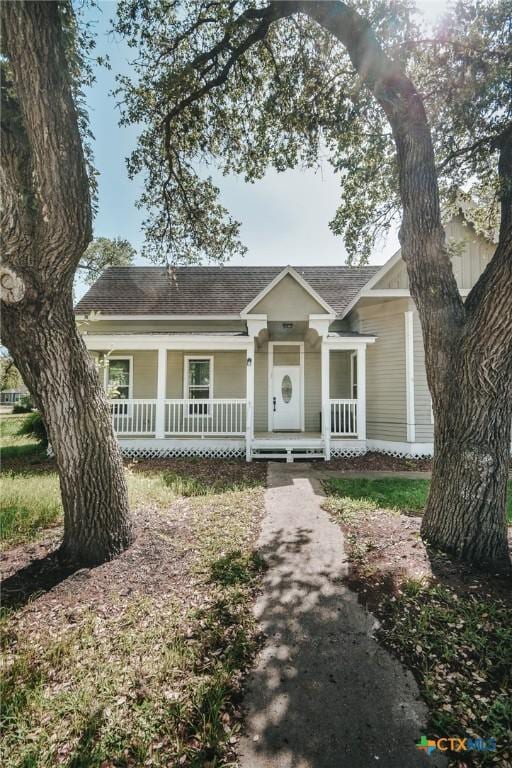 view of front facade with a shingled roof and covered porch