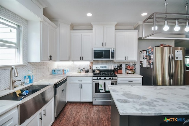 kitchen with white cabinets, stainless steel appliances, light stone counters, and a sink