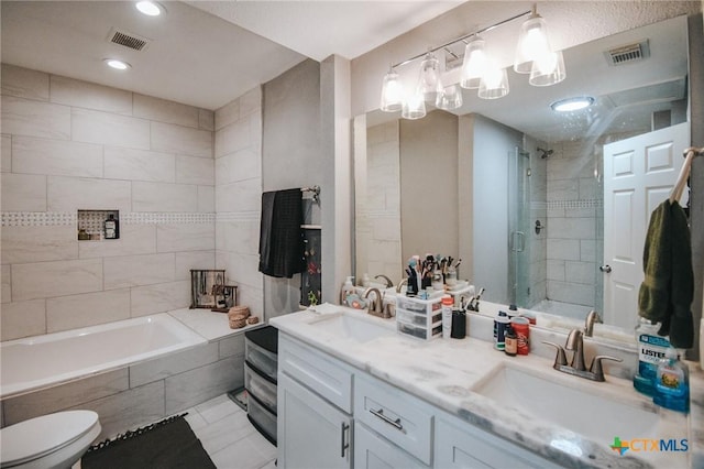 bathroom featuring tiled shower, visible vents, and a sink