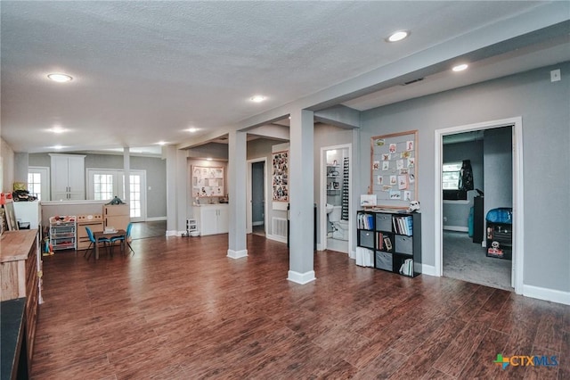 living room with recessed lighting, baseboards, a textured ceiling, and dark wood-type flooring