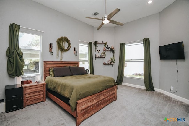 bedroom featuring light colored carpet, baseboards, visible vents, and multiple windows