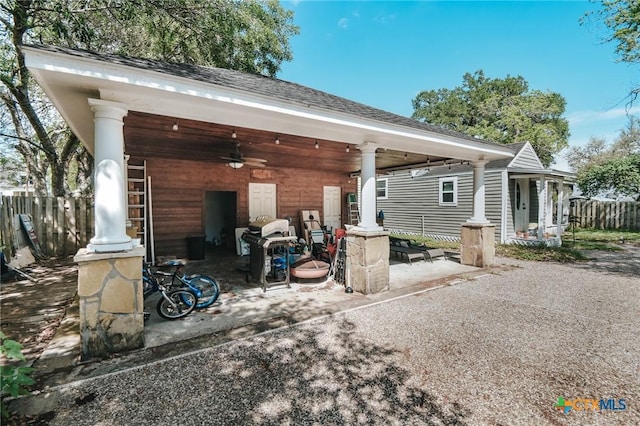 rear view of house featuring a shingled roof, ceiling fan, a patio area, and fence