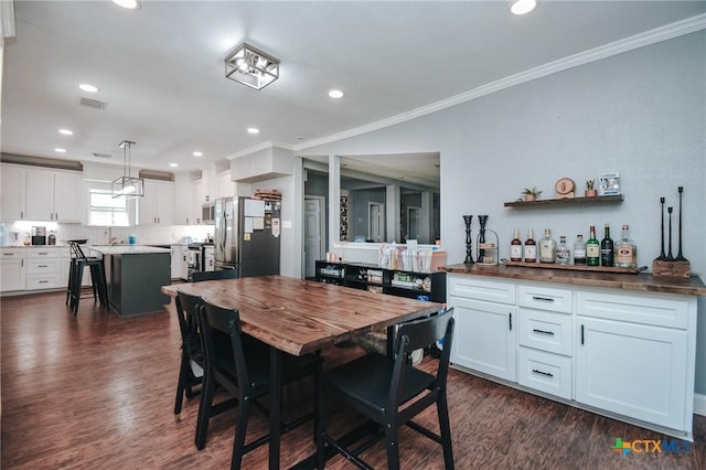 dining space with recessed lighting, visible vents, ornamental molding, and dark wood-type flooring