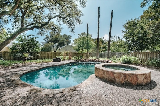 view of swimming pool featuring an in ground hot tub and a fenced backyard