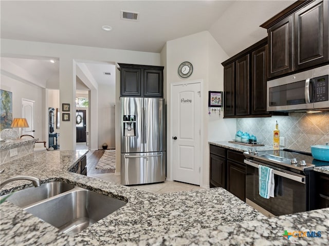 2136 Pioneer Pass, Seguin, TX 78155 - kitchen featuring stainless steel appliances, a sink, light stone countertops, tasteful backsplash, and light tile patterned flooring