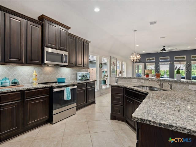 2136 Pioneer Pass, Seguin, TX 78155 - kitchen featuring appliances with stainless steel finishes, a sink, tasteful backsplash, light stone countertops, and recessed lighting