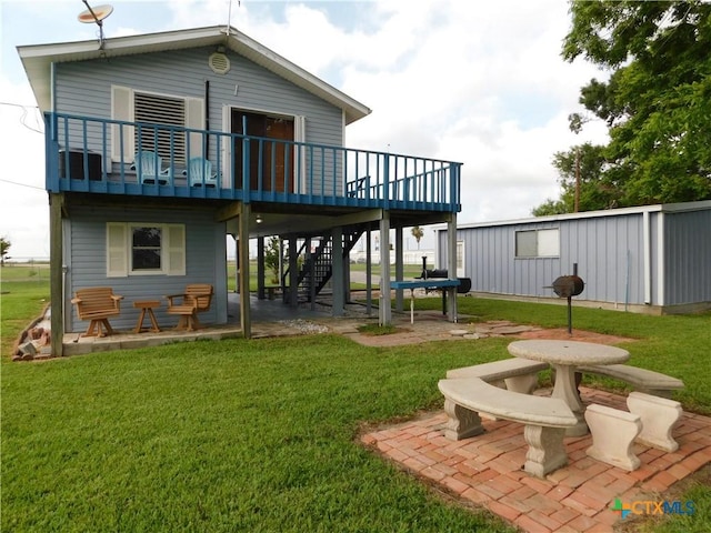 135 W Bayshore Dr, Palacios, TX 77465 - rear view of property featuring a lawn, a patio area, stairway, and a wooden deck