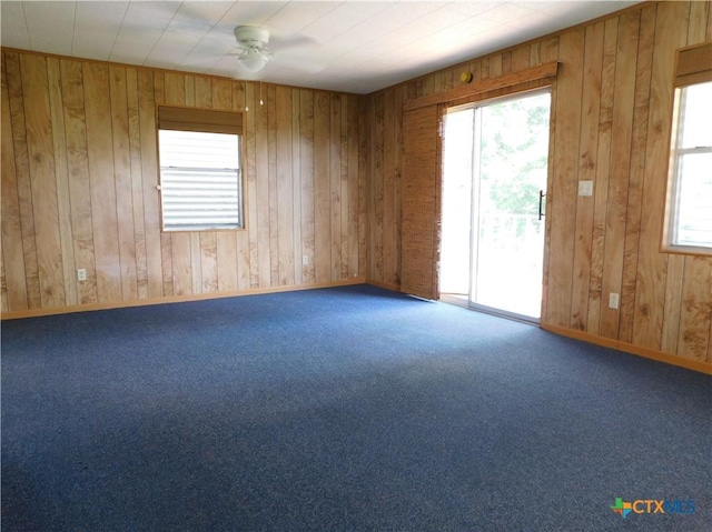 135 W Bayshore Dr, Palacios, TX 77465 - carpeted spare room with wood walls, ceiling fan, and baseboards
