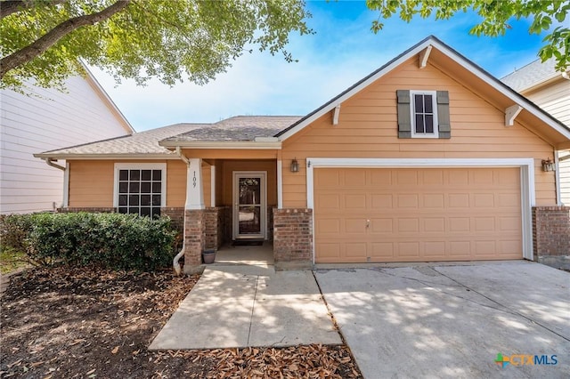 view of front of property with brick siding, an attached garage, and concrete driveway