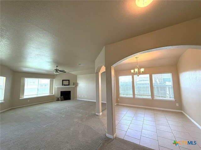 2602 Camp Cooper Dr, Killeen, TX 76549 - unfurnished living room featuring arched walkways, a chandelier, baseboards, a textured ceiling, and a ceiling fan
