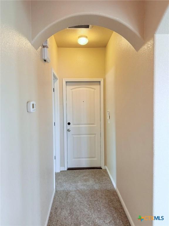 2602 Camp Cooper Dr, Killeen, TX 76549 - hallway featuring carpet flooring, arched walkways, and baseboards