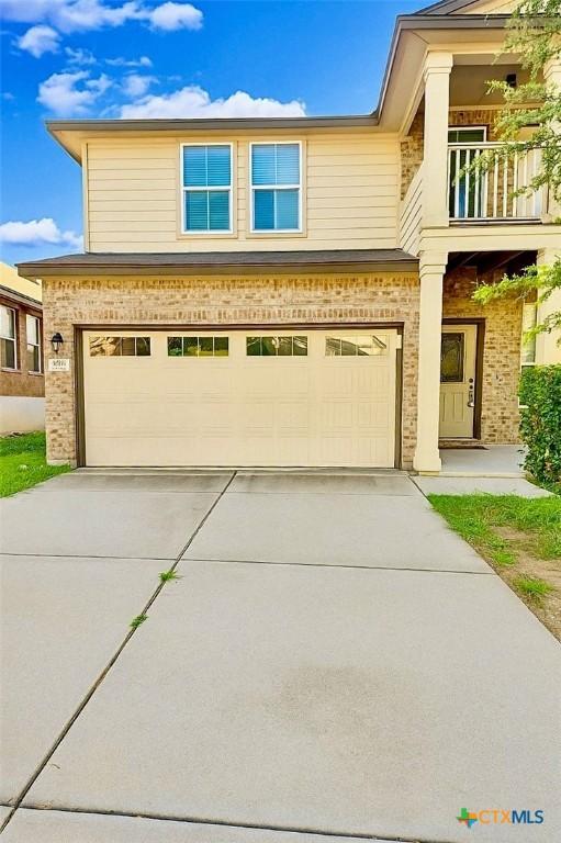 9511 Adeel Dr, Killeen, TX 76542 - view of front of house featuring a garage, driveway, a balcony, and brick siding