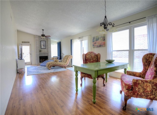 5110 Sam Houston, Temple, TX 76502 - dining room featuring a textured ceiling, a chandelier, wood finished floors, a brick fireplace, and ceiling fan