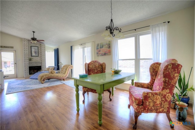 5110 Sam Houston, Temple, TX 76502 - dining room featuring a textured ceiling, wood finished floors, a chandelier, a fireplace, and ceiling fan