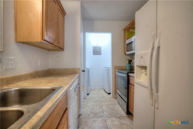 5110 Sam Houston, Temple, TX 76502 - kitchen featuring white appliances, a textured ceiling, washer and dryer, light countertops, and light tile patterned floors