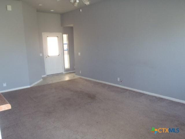 empty room featuring carpet, baseboards, and ceiling fan