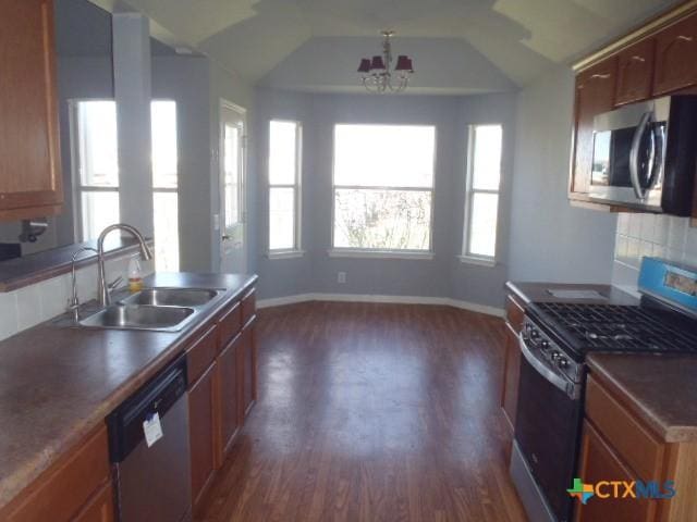 kitchen featuring dark wood-type flooring, a sink, baseboards, appliances with stainless steel finishes, and tasteful backsplash