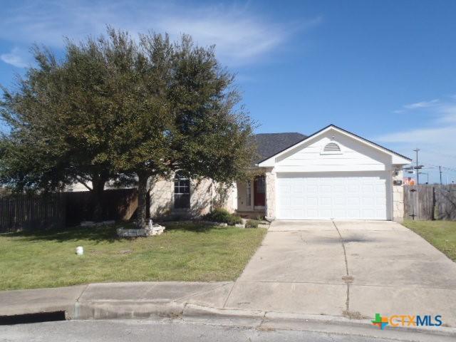 view of front of house featuring an attached garage, driveway, a front lawn, and fence