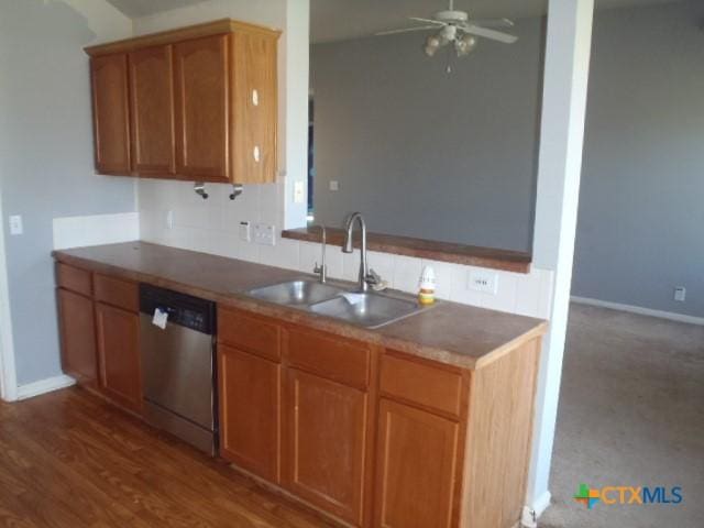 kitchen featuring baseboards, a ceiling fan, dark wood-style floors, stainless steel dishwasher, and a sink