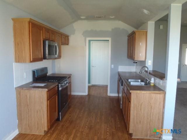 kitchen with visible vents, appliances with stainless steel finishes, a sink, and dark wood finished floors