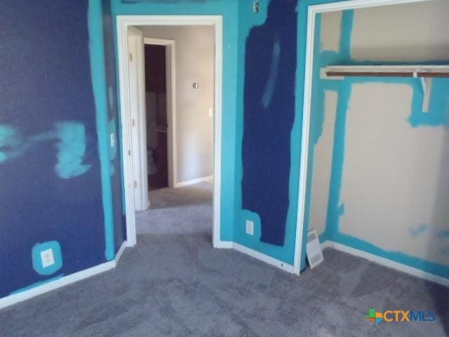 unfurnished bedroom featuring a closet, carpet flooring, and baseboards